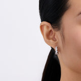 On-body view of a model wearing the Wallace Bishop Cubic Zirconia Cluster Huggies in Sterling Silver, 15mm in length, hugging the earlobe with a scatter of colourless cubic zirconias.