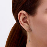 On-body view of a model wearing the Wallace Bishop Cubic Zirconia Trilogy Threader Earrings in 9ct Yellow Gold, with the fine chain threaded through the piercing and the three-stone trilogy drop hanging below the earlobe.