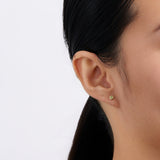 On-body view of a model wearing the Wallace Bishop Peridot Bezel Stud Earrings in 9ct Yellow Gold, with a 3mm round peridot in each earlobe.