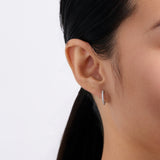 On-body view of a model wearing the Wallace Bishop 0.25 TDW Round Lab-Grown Diamond Huggies in Sterling Silver, 12.20mm in length, hugging the earlobe with a row of claw-set round lab-grown diamonds.