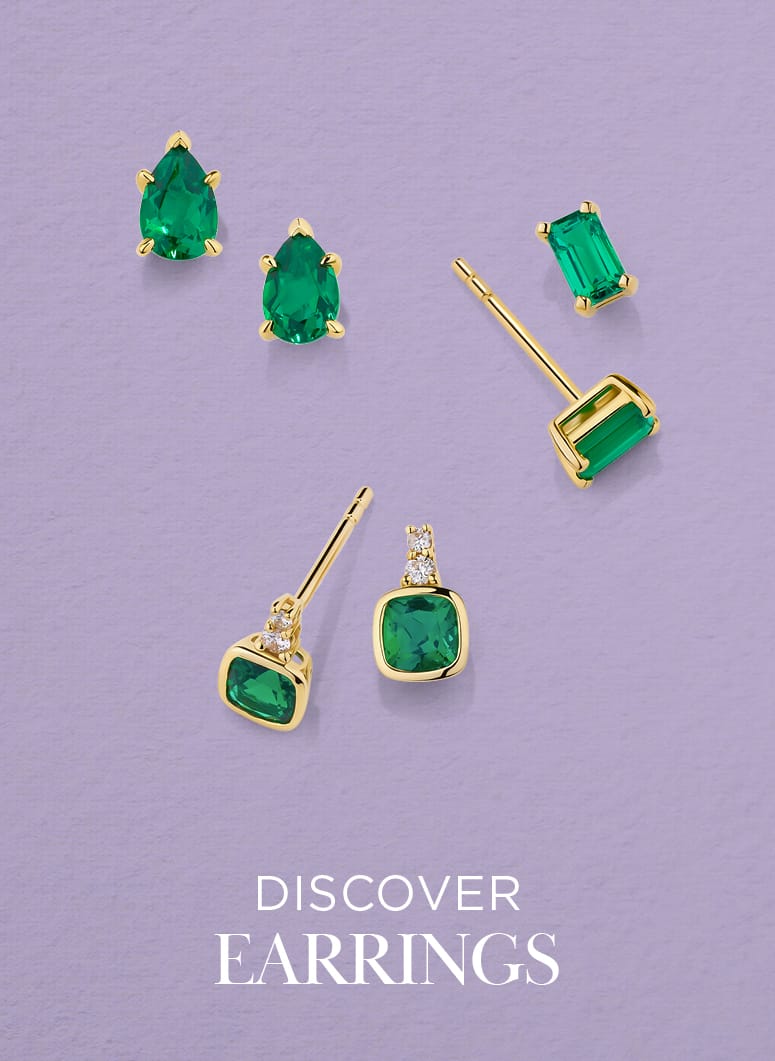 Set of green gemstone earrings with gold frames on a purple background