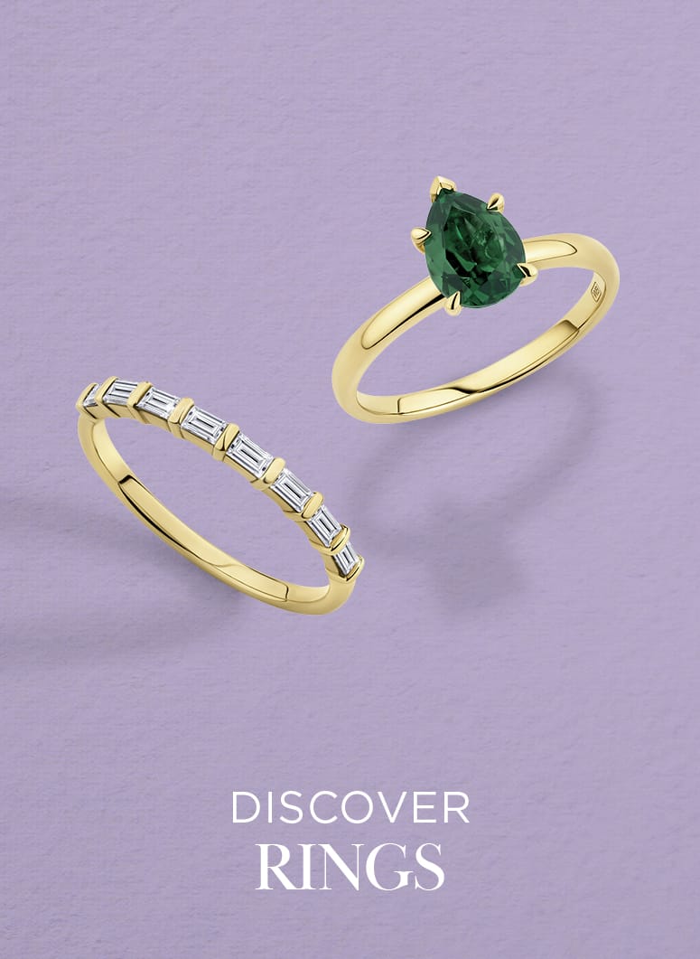 Two gold rings with gemstones on a purple background