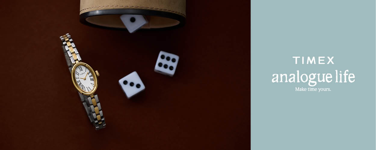 Timex analogue watch with dice and a leather case on a brown surface