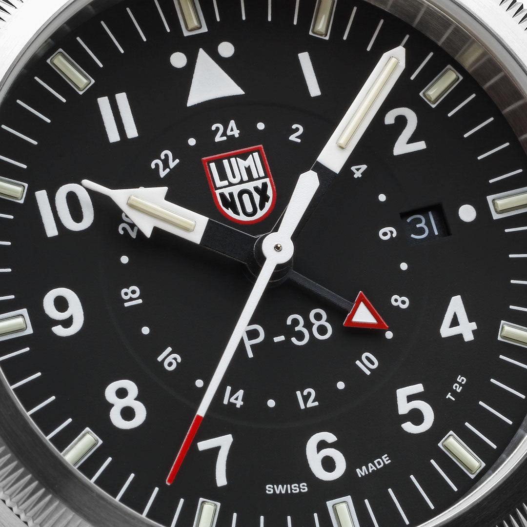 Close-up of the black dial on the Luminox Air Pilot P-38 Lightning Men's 42mm Quartz GMT Watch XA.9521, showing the Arabic numerals, baton markers, second time zone hand and date window. This P-38 Lightning pilot's watch features self-powered tritium tubes for constant visibility in the dark.