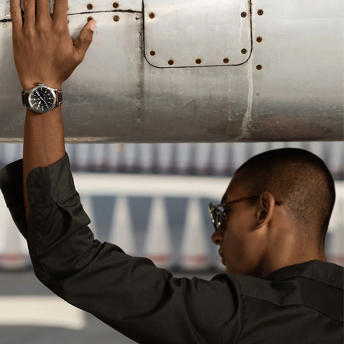 Luminox Air Pilot P-38 Lightning Men's 42mm Quartz GMT Watch XA.9521 worn on the wrist to show its size and fit. This P-38 Lightning pilot's watch features a black dial, a stainless steel case and a brown leather strap.