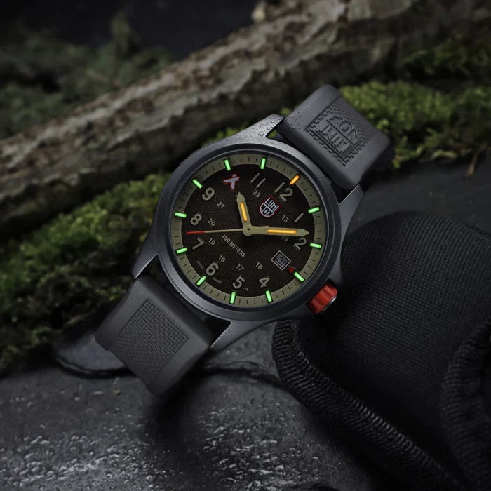 Luminox Bear Grylls Survival Land Men's 43mm Quartz Watch XB.3716 shown in a rugged outdoor adventure setting. This Bear Grylls Survival Land 3710 Series watch features a sand-coloured dial, a lightweight aluminium case and 100m water resistance.