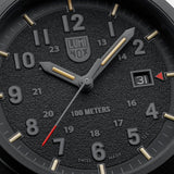 Close-up of the textured black dial on the Luminox Atacama Field Men's 43mm Quartz Watch XL.1961, showing the 12 and 24-hour numerals, red-tipped seconds hand and red arrow beside the date at 3 o'clock. This Atacama Field watch features self-powered tritium tubes for constant visibility in the dark.