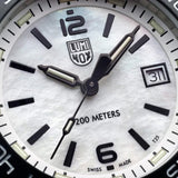 Close-up of the blue mother-of-pearl dial on the Luminox Pacific Diver Ripple Men's 39mm Quartz Watch XS.3124M, showing its natural shimmer, luminous hands and hour markers. This Pacific Diver Ripple dive watch features a date window and self-powered tritium tubes that glow constantly for up to 25 years.