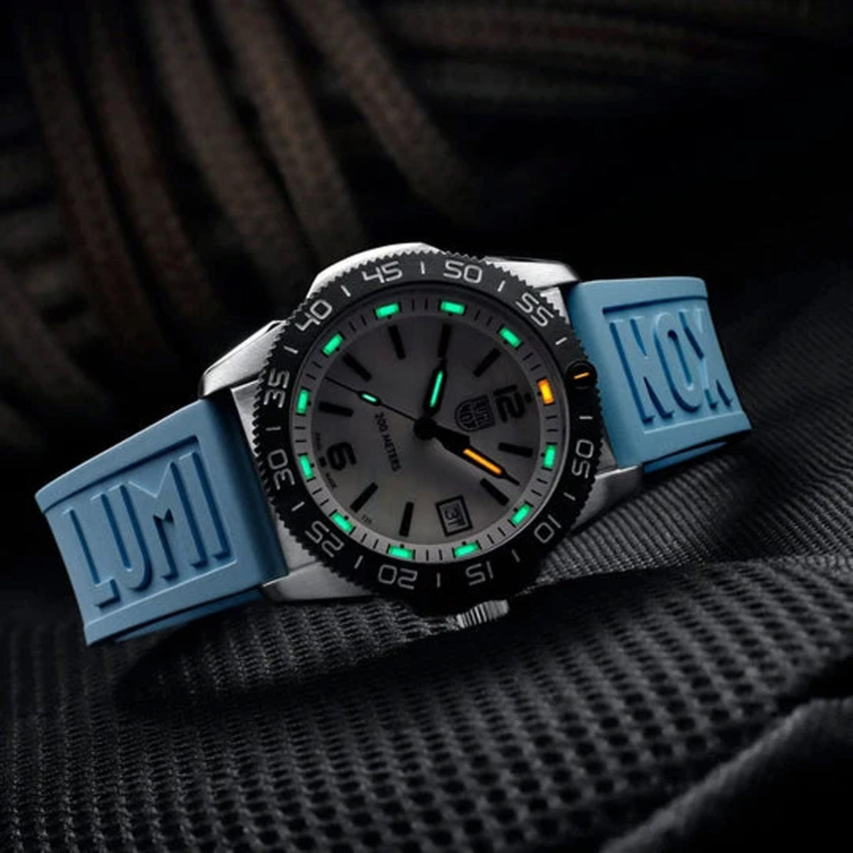 Luminox Pacific Diver Ripple Men's 39mm Quartz Watch XS.3124M shown in a coastal outdoor setting. This Pacific Diver Ripple dive watch features a blue mother-of-pearl dial, a stainless steel case and 200m water resistance.