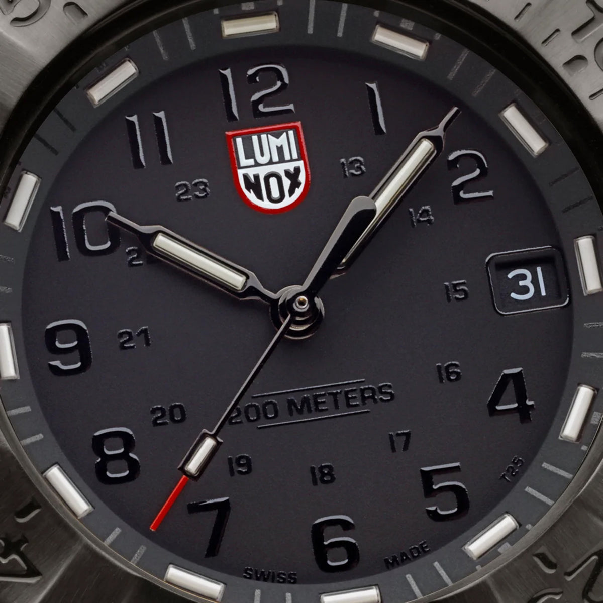 Close-up of the black dial on the Luminox Navy SEAL Foundation Men’s 43mm Quartz Watch XS.3228.NSF, showing the luminous hands, markers and date window at 3 o’clock. This Navy SEAL Foundation 3220 Series watch features ice blue and golden yellow self-powered tritium tubes.