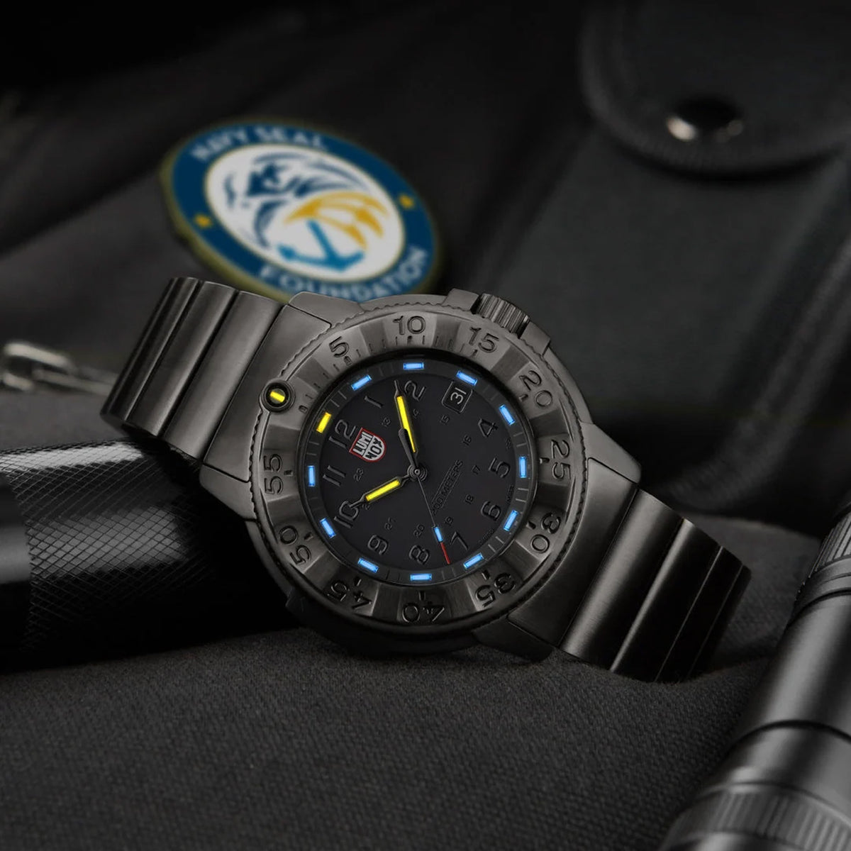 Luminox Navy SEAL Foundation Men’s 43mm Quartz Watch XS.3228.NSF shown in a rugged outdoor setting. This Navy SEAL Foundation 3220 Series dive watch features a black dial, a gunmetal steel bracelet and 200m water resistance.