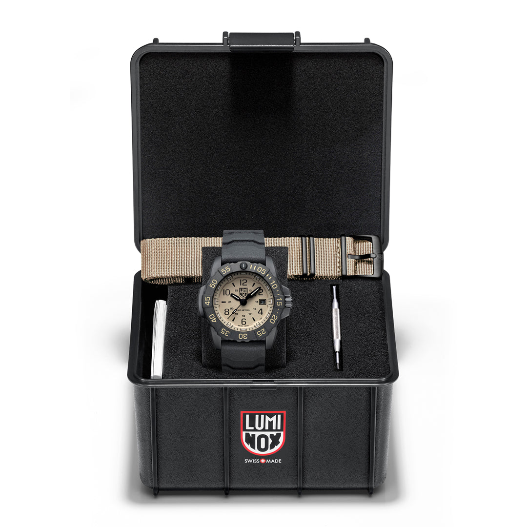 A Luminox Navy SEAL FoundationWatch with a black band and case, featuring a Tan face and additional strap in a box