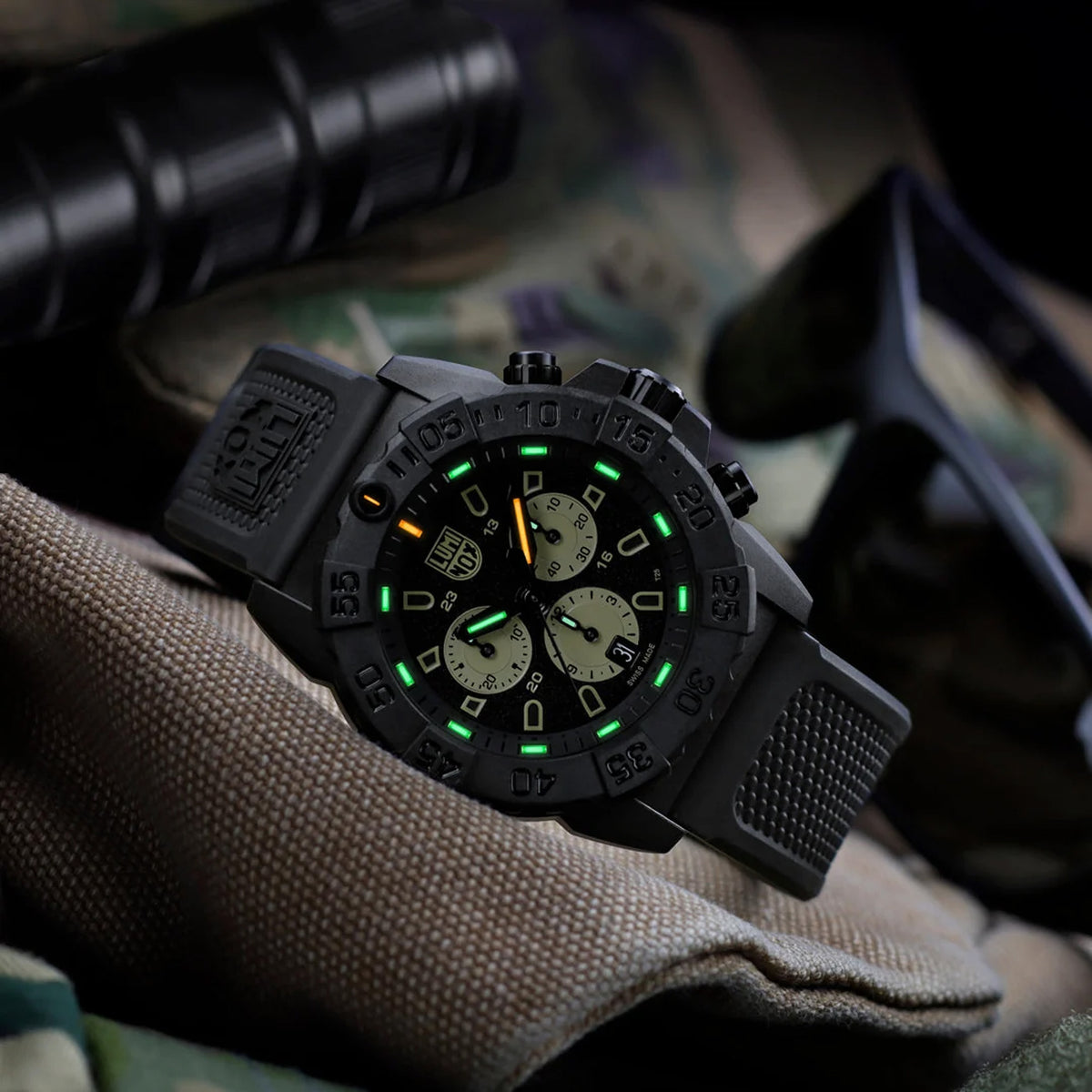 Luminox Navy SEAL Chronograph Men’s 45mm Quartz Watch XS.3587 shown in a rugged desert-inspired outdoor setting. This Navy SEAL Chronograph 3580 Series dive watch features a sand and black dial, a lightweight CARBONOX™ case and 200m water resistance.