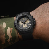 : Luminox Navy SEAL Chronograph Men’s 45mm Quartz Watch XS.3587 worn on the wrist to show its size and fit. This Navy SEAL Chronograph 3580 Series watch features a black dial with sand-coloured sub-dials, a black dive bezel and a lightweight CARBONOX™ case on a black rubber strap.