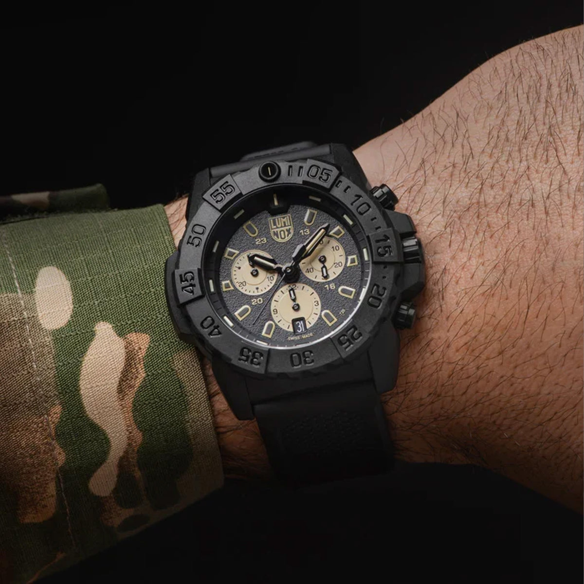 : Luminox Navy SEAL Chronograph Men’s 45mm Quartz Watch XS.3587 worn on the wrist to show its size and fit. This Navy SEAL Chronograph 3580 Series watch features a black dial with sand-coloured sub-dials, a black dive bezel and a lightweight CARBONOX™ case on a black rubber strap.
