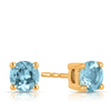 A pair of 9ct yellow gold stud earrings shown front on, featuring a 4mm round cut blue topaz in a claw setting. Styled as a December birthstone piece, with a matching necklace available separately.