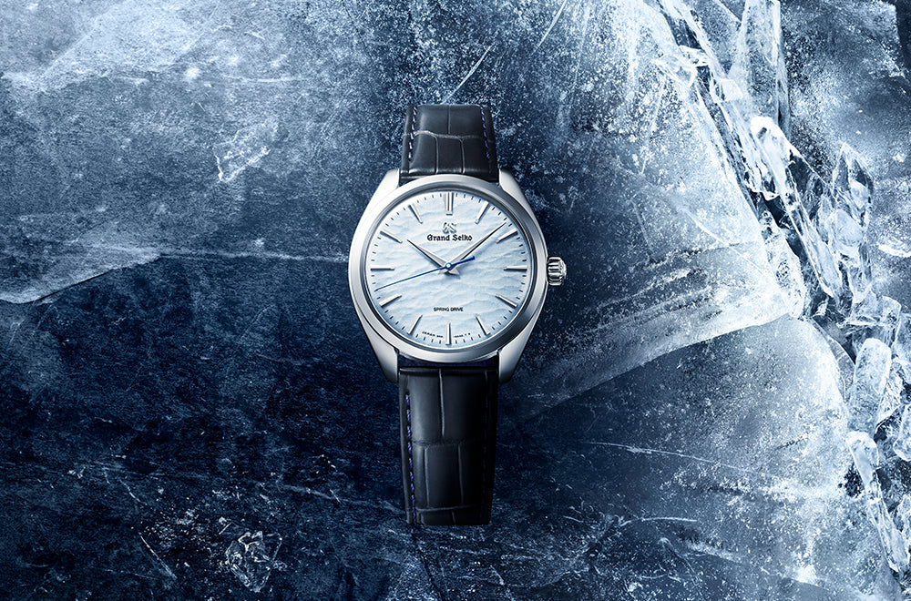 Grand Seiko watch with black leather strap on a textured blue background