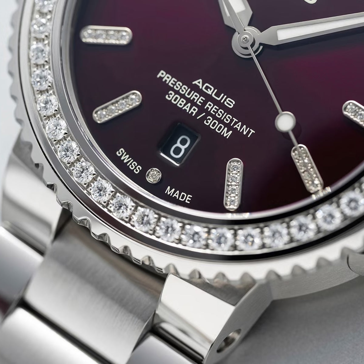 Close-up of the red dial on the Oris Aquis Date Relief 41.50cmm Automatic Watch 733 7766 4998MB, showing the 44 set diamonds and Superluminova-treated hands and indices. The diamond-set case detail is shown up close.