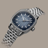 This 3/4 angle view of the Raymond Weil Freelancer Women’s 34.5mm Automatic Watch 2490-STS-50051 shows the lab-grown diamond bezel catching the light above the gradient blue dial. The fluted crown and bracelet links are visible along the side of the case.