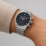 The Loyal Academy Steel Chronograph Watch worn on the wrist, showing the true scale of the 40mm case and black chronograph dial. The stainless steel finish and matching bracelet give this quartz watch a sporty, versatile look for daily wear.