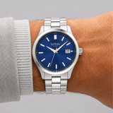 The Loyal Academy Stainless Steel Watch worn on the wrist, showing the true scale of the 40mm case and blue dial. The stainless steel finish and matching bracelet give this quartz watch a sporty, versatile look for daily wear.