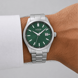 The Loyal Academy Steel Watch worn on the wrist, showing the true scale of the 40mm case and green dial. The stainless steel finish and matching bracelet give this quartz watch a sporty, versatile look for daily wear.