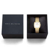 The Daniel Wellington Cort H-Link Women’s 30mm Quartz Watch DW00100985 displayed in its Daniel Wellington presentation box. The gold case, off-white dial and H-link bracelet are presented ready for gifting.