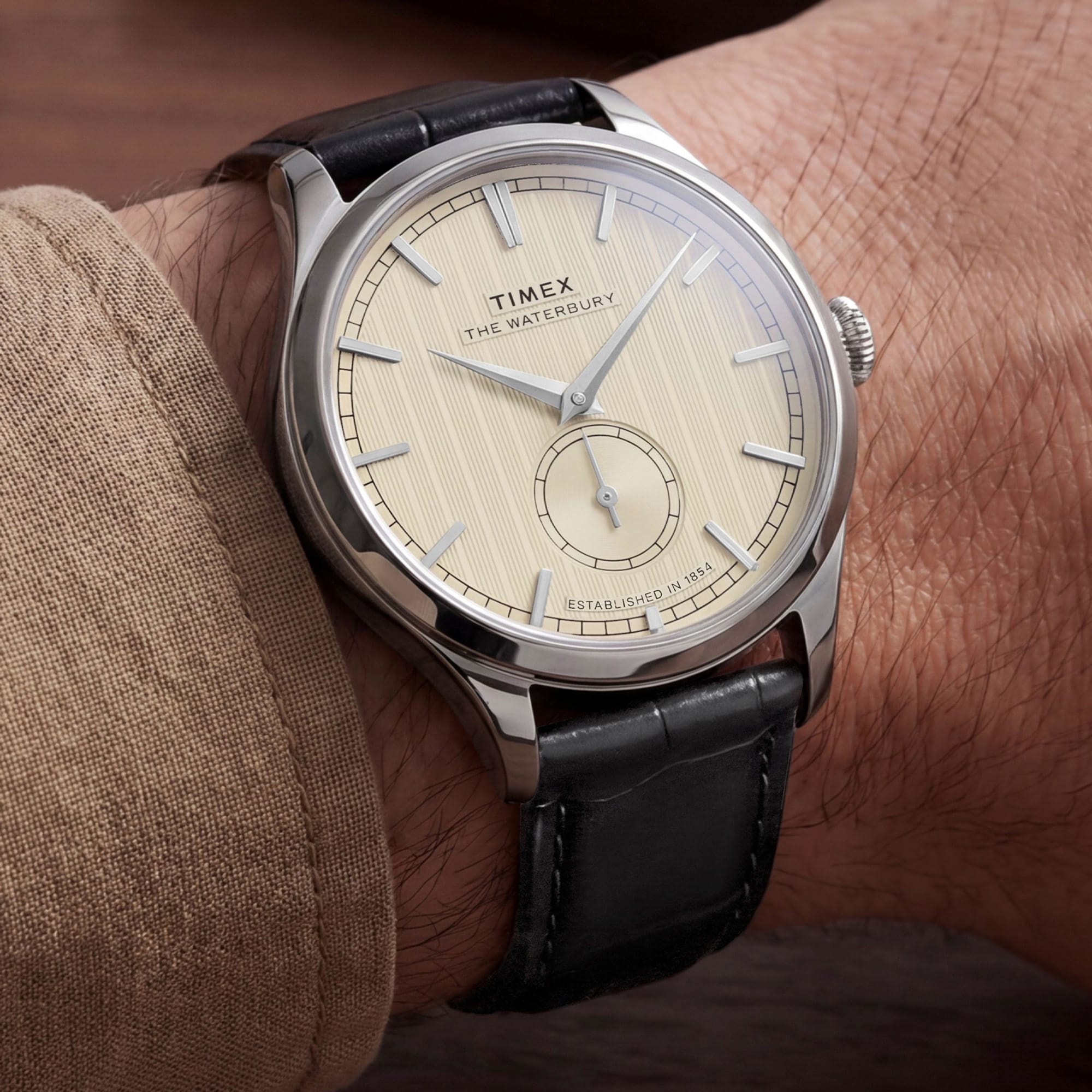 The Timex Waterbury Traditional Quartz 39mm Watch TW2Y92000 pairs its polished silver-tone stainless steel case with a black leather strap for a classic, considered look. The white dial adds a crisp contrast against the black strap.