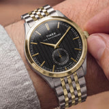The Timex Waterbury Traditional Quartz 39mm Watch TW2Y91900 pairs its polished stainless steel case with a two-tone stainless steel bracelet for a fully steel, considered look. The gold-tone accents add warmth against the two-tone bracelet.