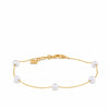 Freshwater Pearl Station Bracelet in 9ct Yellow Gold — five round white freshwater pearls, each 4-4.5mm, stationed individually along a fine gold chain. The bracelet includes a lobster clasp and a small gold charm detail near the fastening, shown here against a plain background to highlight the pearls' natural lustre.