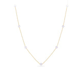A delicate gold chain necklace featuring five evenly spaced, small white pearl beads, displayed on a clean white background.
