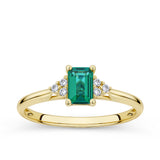 Front-on view of the Wallace Bishop 0.06 TDW Emerald-Cut Created Emerald & Diamond Ring in 9ct Yellow Gold, reference 38EMD040YO, on a plain polished band. The ring features a 6x4mm emerald cut created emerald centre stone flanked by a cluster of three round brilliant cut natural diamonds on each side.