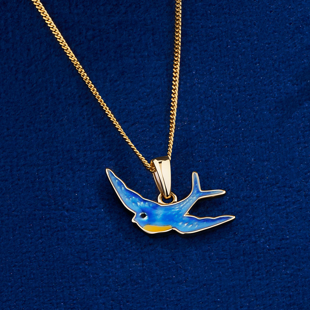Flat lay view of the Wallace Bishop Bluebird of Happiness Pendant in 9ct Yellow Gold, reference 35BB07, measuring 17.50mm in length, laid flat on a 400mm (approximately 15.7 inch) chain. The small bluebird is finished in bright blue enamel.
