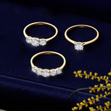 Front-on view of three Wallace Bishop diamond rings in 9ct Yellow Gold: the 0.23 TDW Round Diamond Solitaire Engagement Ring, reference 3SBRIL23YWO, with a single natural round brilliant cut diamond on a polished band, the 0.39 TDW Round Diamond Three Stone Engagement Ring, reference 11BRIL3STYWO, and the 0.38 TDW Round Diamond Five Stone Engagement Ring, reference 11BRIL5STYWO. The three stone and five stone rings feature natural round cut diamonds set into white gold illusion settings on a polished plain 