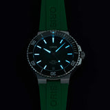 Oris Aquis Date Calibre 400 43.50mm Automatic Watch 01 400 7790 4157-07 4 23 47EB photographed in low light — The Super-LumiNova coating on the baton indices and hands glows clearly in the dark, making the time easy to read underwater or in low-light conditions. The luminous pip on the rotating bezel is also visible, confirming the watch’s dive functionality.