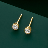 Flat lay view of the Wallace Bishop Round Cubic Zirconia Stud Earrings in 9ct Yellow Gold, reference 68ECZB03, laid flat. Each earring features a 3mm round cubic zirconia in a bezel setting.