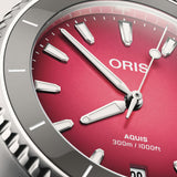 Close-up of Oris Aquis Date Taste of Summer gradient pink-red sunburst dial with date window and ceramic rotating bezel