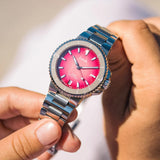 Close-up of Oris Aquis Date Taste of Summer gradient pink-red sunburst dial with date window and ceramic rotating bezel