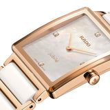 Close up of Rado watch with rose gold and white ceramic band and mother of pearl dial