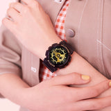 Casio Baby-G BA110X-1A women's watch front view, featuring a 46.3mm all-black round resin case with a deeply layered three-dimensional dial, gear-inspired index markings, analogue hands, and a lower digital LCD display window.