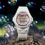 Lifestyle shot of the Casio Baby-G Digital Women's Watch BG169GD-7D, 42mm case, styled in an everyday casual setting. The matte off-white finish and compact round silhouette are shown in a natural, real-world context.