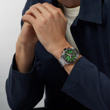 TAG Heuer Formula 1 Chronograph CAZ101AP.BA0842 shown worn on the wrist, illustrating the case proportions and steel bracelet fit. The green dial stands out against the sleeve in frame.