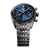 TAG Heuer Carrera Chronograph CBS2212.BA0048 photographed at an angle highlighting the blue dial's domed sapphire crystal and bezel-free case. The steel bracelet curves away from the lugs, showing its link construction.