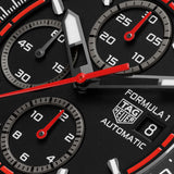 Close up of Dial of ablack TAG Heuer Formula 1 Chronograph watch with a red strap and red accents on the watch face.