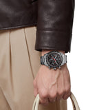TAG Heuer Carrera Chronograph Sport CDB2110.BA0054 shown worn on the wrist, illustrating the case proportions and steel bracelet fit. The black dial stands out against the sleeve in frame.