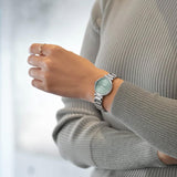 The Citizen L May Bells EM1070-83L styled for everyday wear, reflecting its Eco-Drive solar-powered design. Its pale green dial suits both casual and more formal settings.