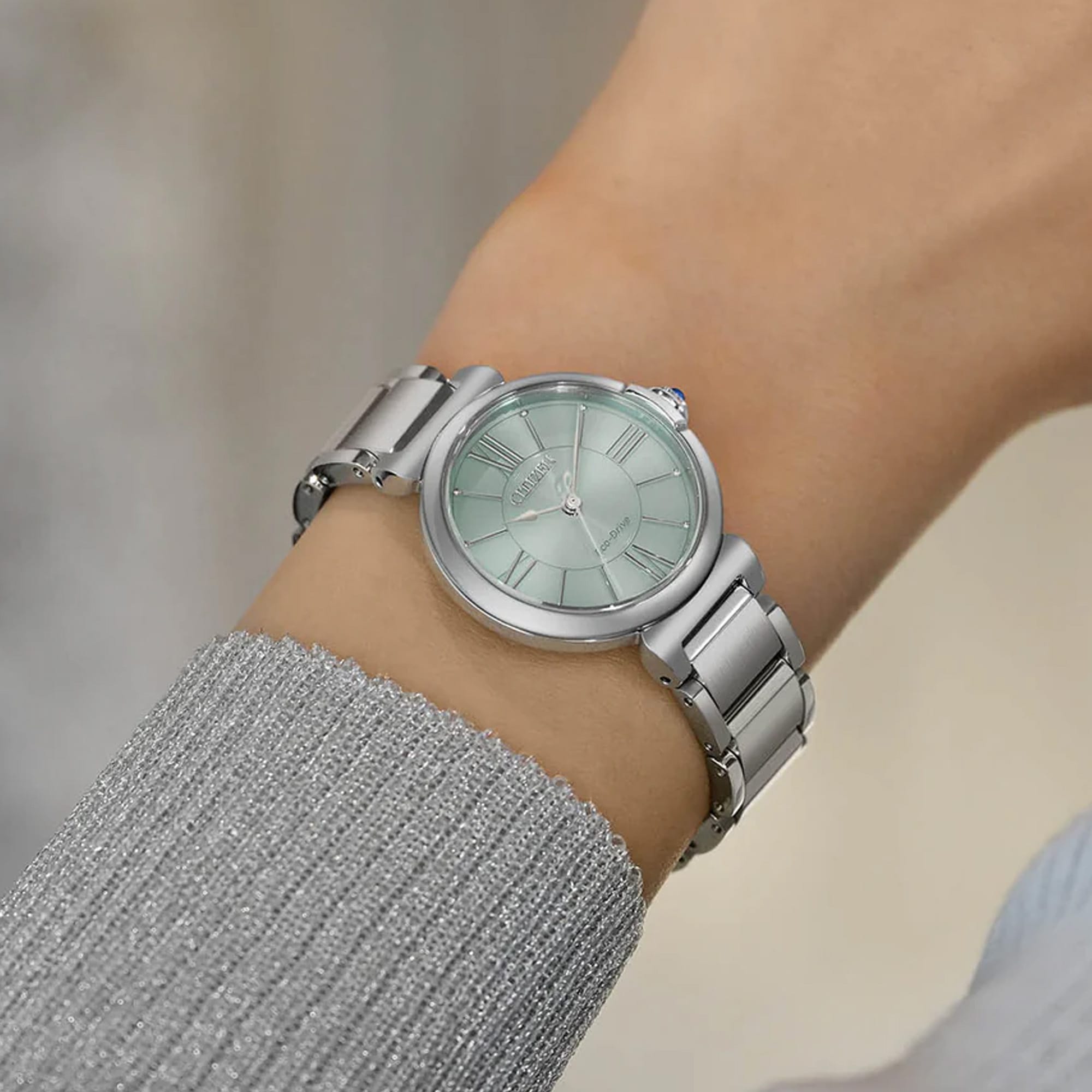 The EM1070-83L worn on the wrist, highlighting its slim 29.5mm case and 8.3mm profile. The stainless steel bracelet sits neatly for everyday wear.