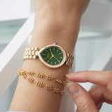 The EM1203-57X worn on the wrist, highlighting its sculpted 26mm by 31mm pear-shaped case. The integrated rose gold-tone bracelet follows the case contours for a seamless fit.