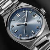 Close-up of a Frederique Constantwatch with a blue sunburst dial, silver stainless steel bracelet, and diamond hour markers on a dark background.