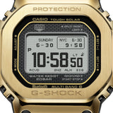 Close-up of the digital display on the Casio G-SHOCK Full Metal GMW-B5000GD-9 Men's Digital Watch, 49mm case, showing the time, date and black dial detail against the gold-tone case. The gold ion-plated finishing on the stainless steel bezel is also visible.